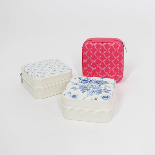 Three jewelry cases with floral and bow patterns on a white background