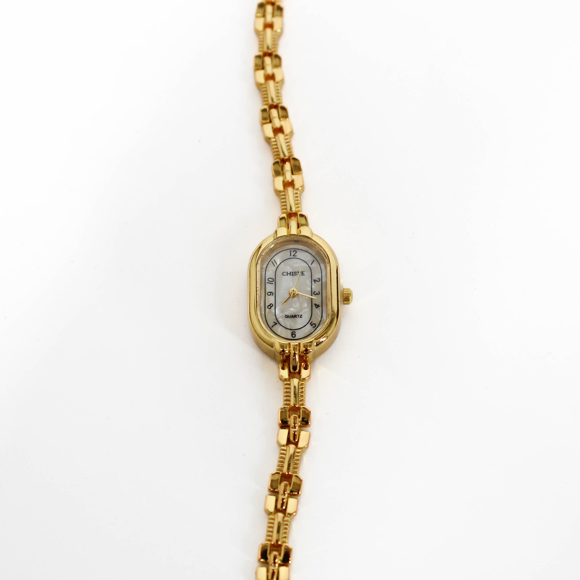 Gold wristwatch with a white face on a white background