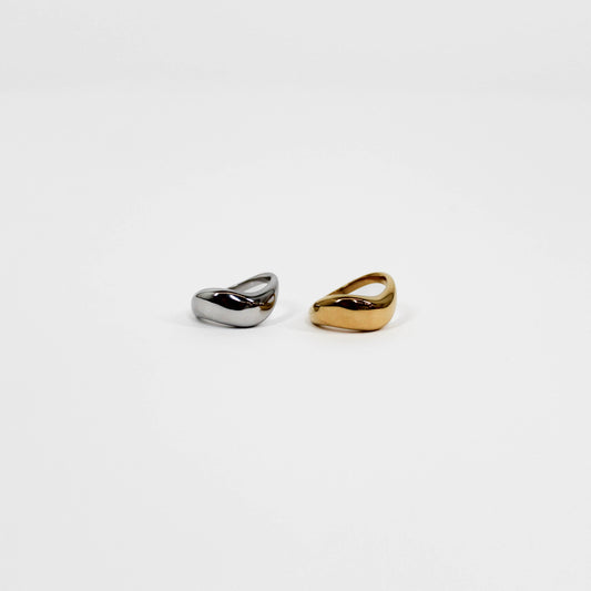 Two gold and silver wavy rings on a white background