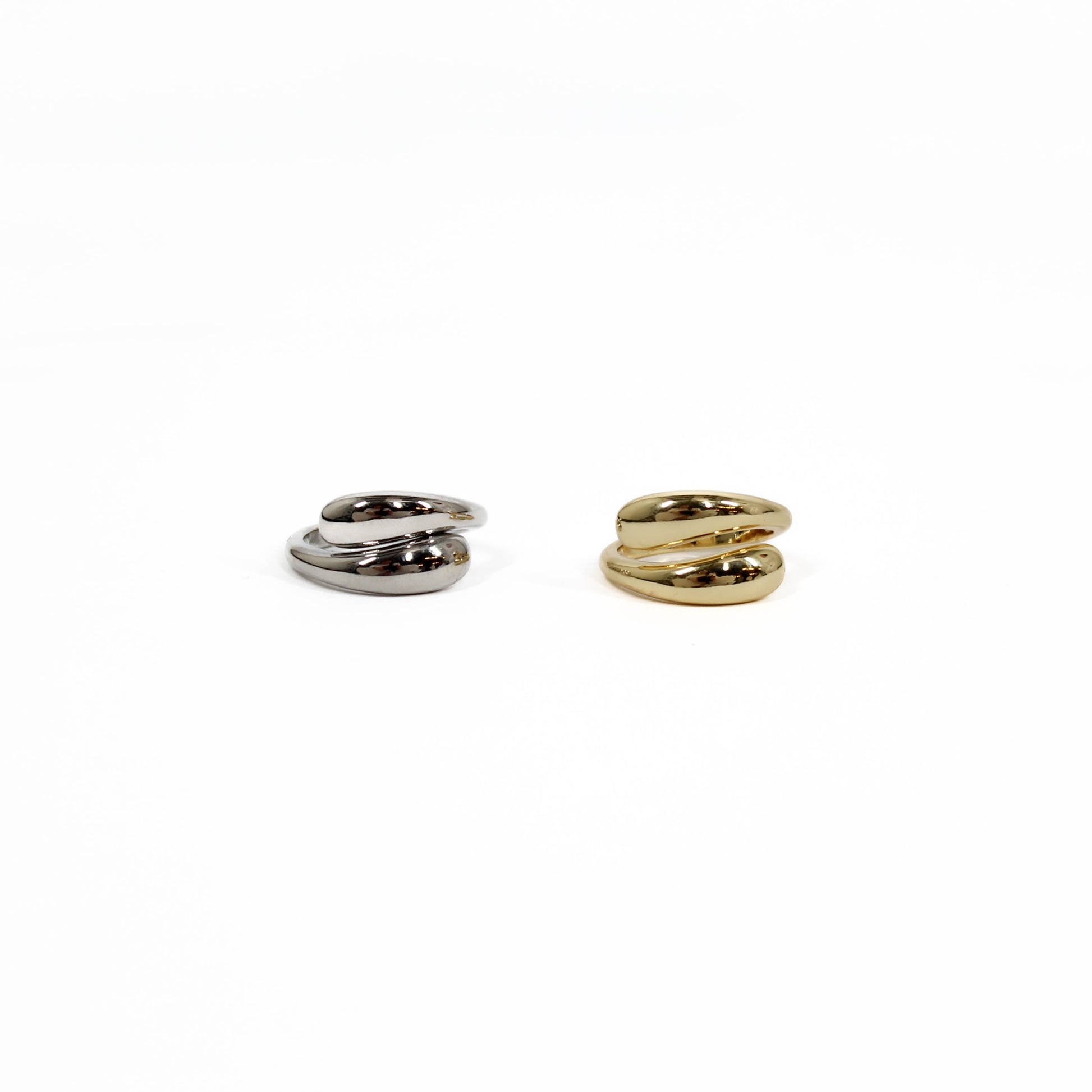 Two spiral-shaped wrap rings, one silver and one gold, on a white background.
