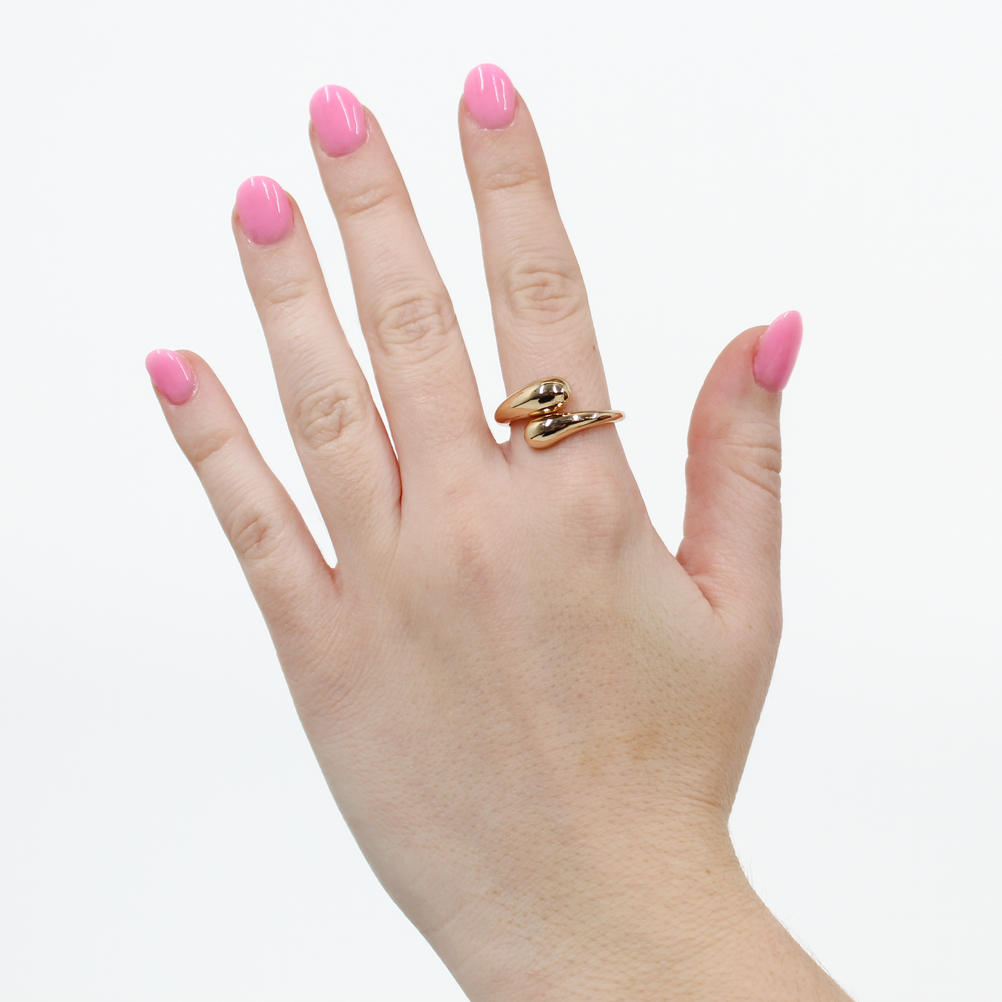 Hand wearing a gold wraparound statement ring on a white background