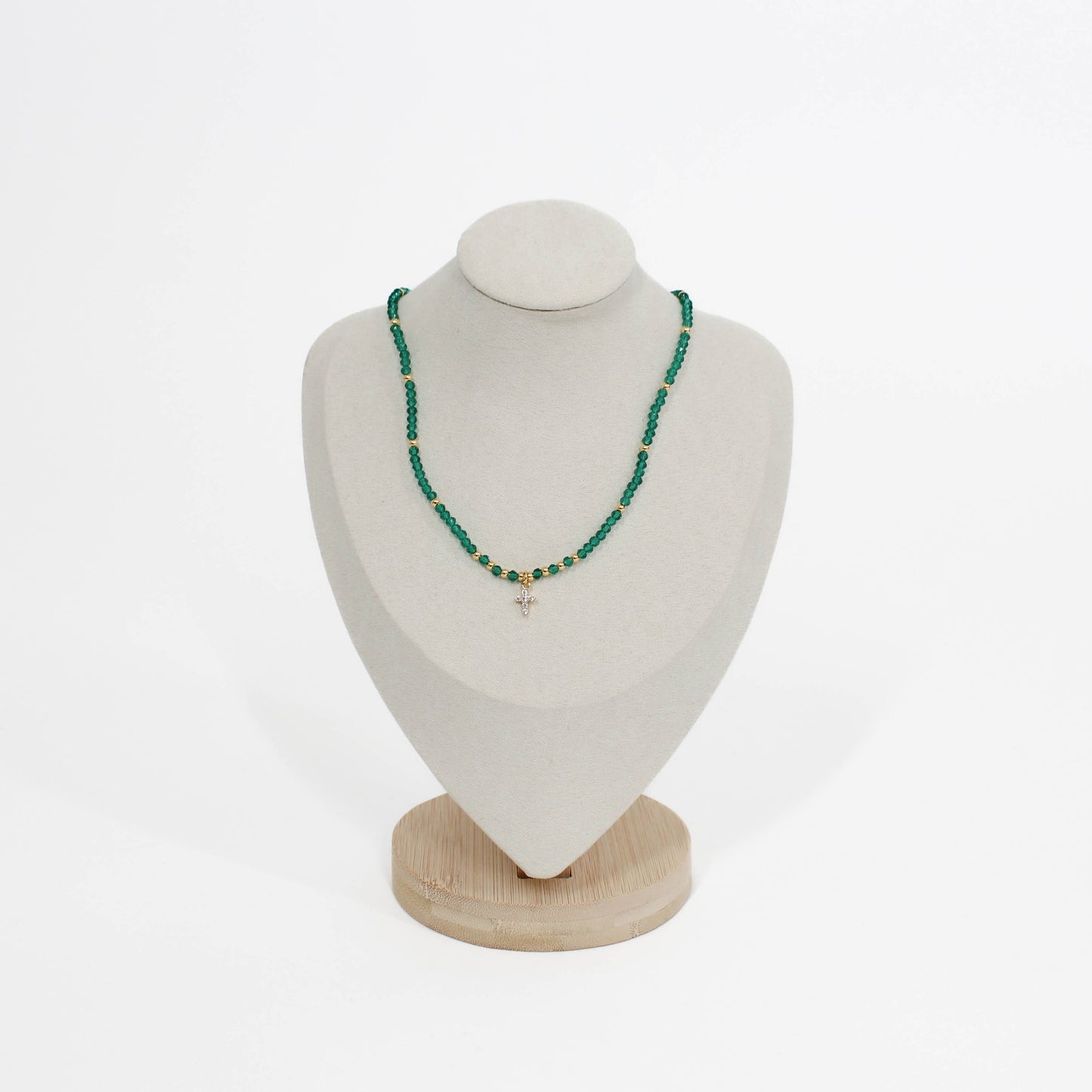 emerald beaded mini cross choker necklace on a white mannequin bust with a wooden base against a white background