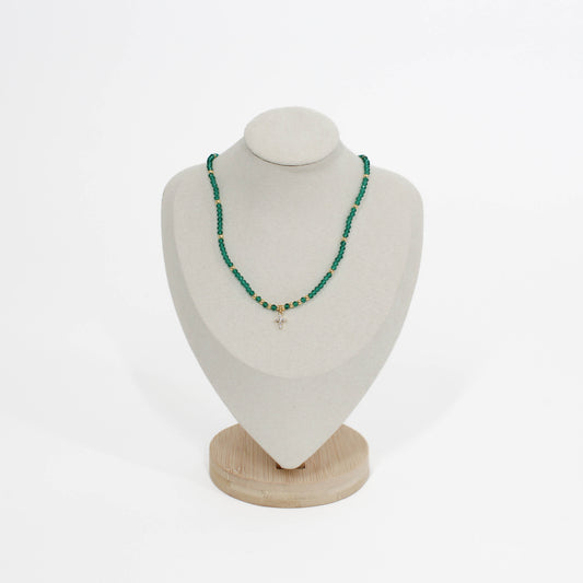 emerald beaded mini cross choker necklace on a white mannequin bust with a wooden base against a white background