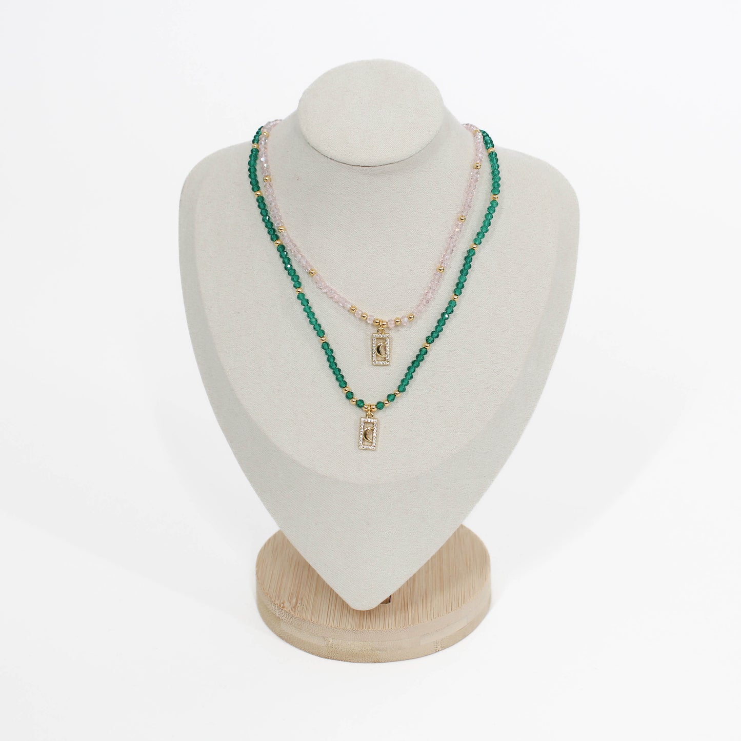 Green and pink beaded moon pave choker necklace on a mannequin bust with a white background