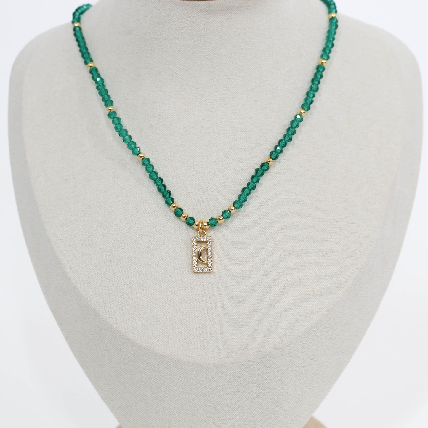 Green beaded moon pave choker necklace with a rectangular pendant on a mannequin bust.