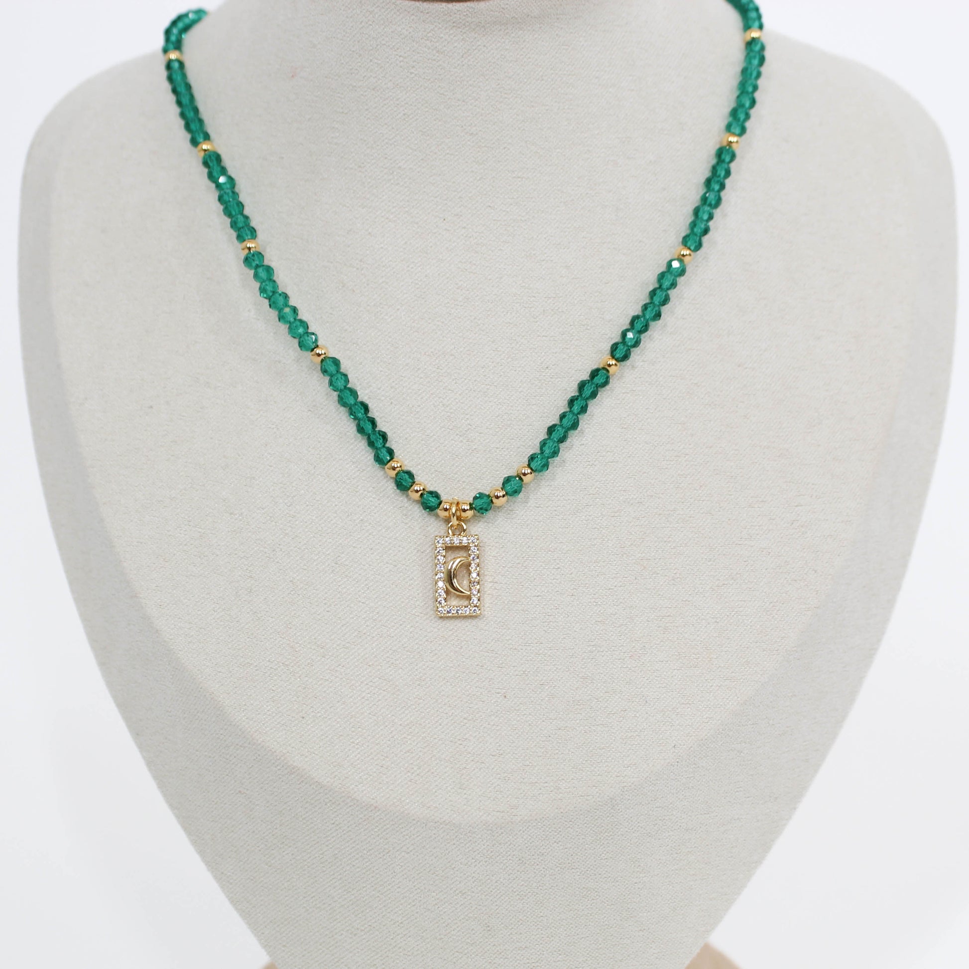Green beaded moon pave choker necklace with a rectangular pendant on a mannequin bust.