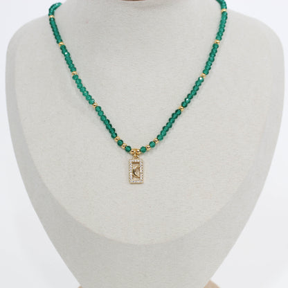 Green beaded moon pave choker necklace with a rectangular pendant on a mannequin bust.
