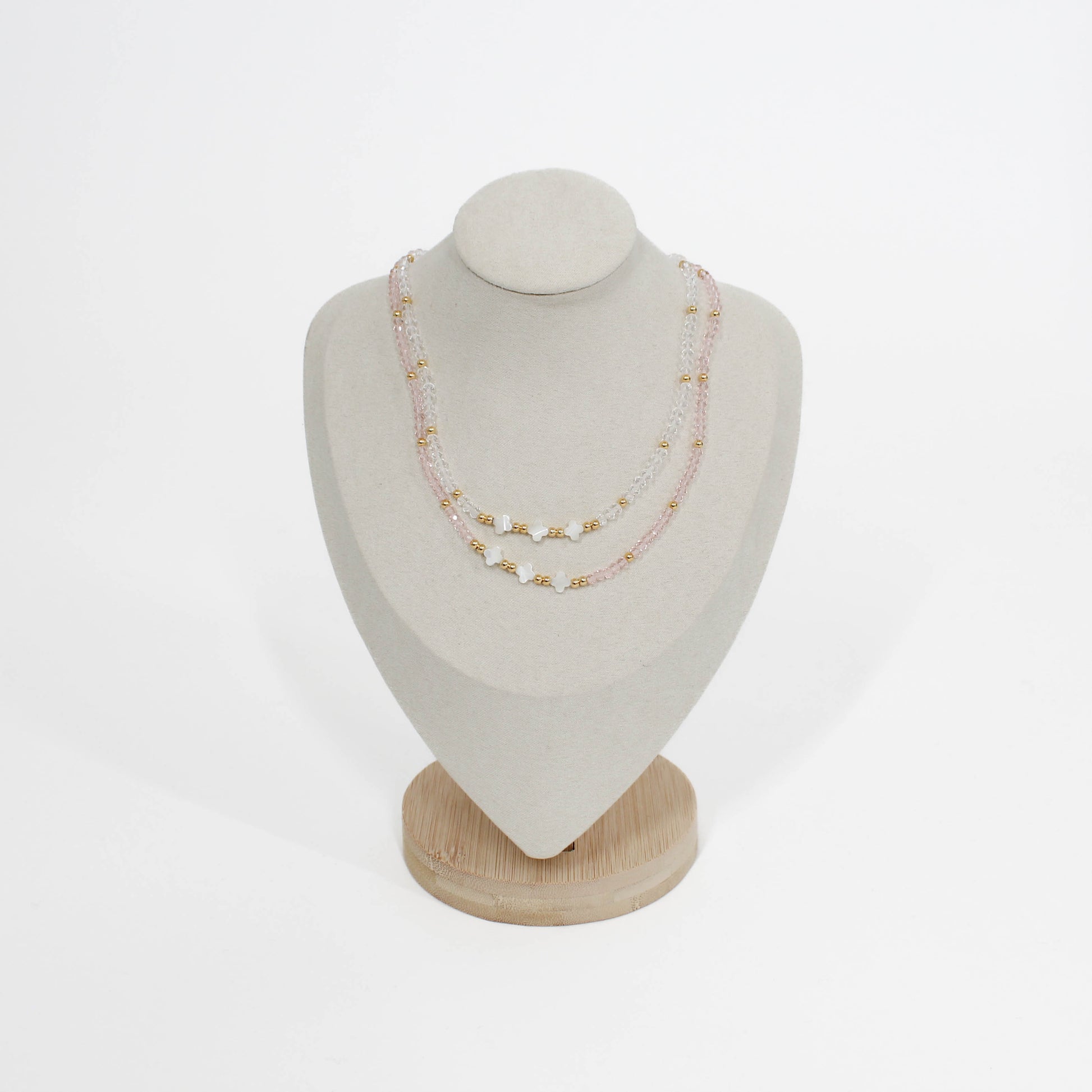 triple clover necklaces on a mannequin bust with a white background