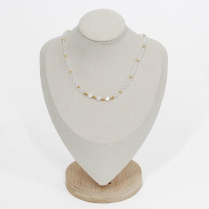 clear triple clover necklace on a white mannequin bust with a white gray background