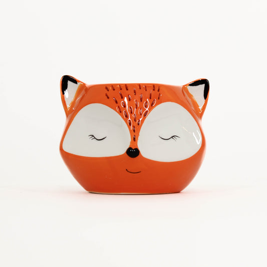Ceramic fox-shaped container on a white background