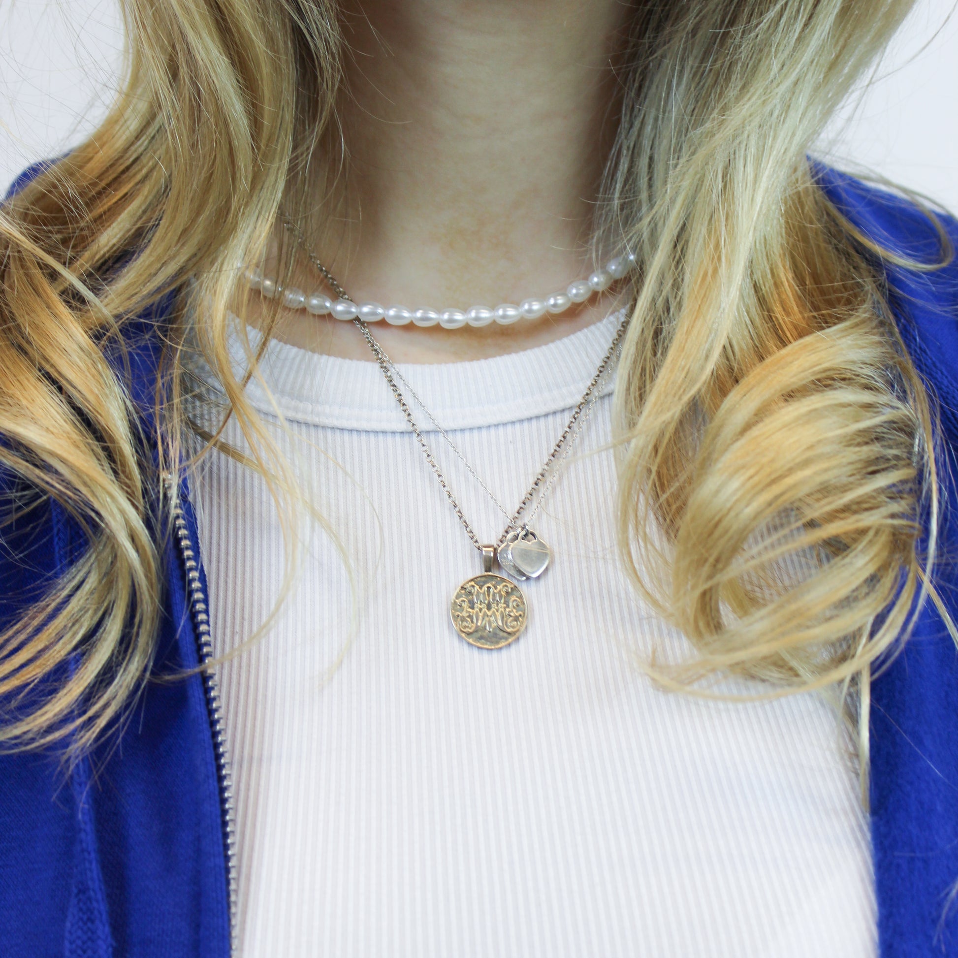 Silver scripted M Disc Necklace for Marist on model 